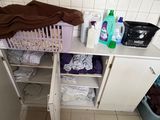 a white cabinet with a bunch of laundry items on it