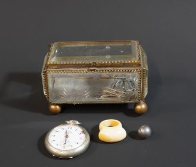 une boîte en argent avec un couvercle en verre et une montre de poche en argent posée à côté