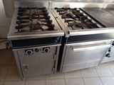two stainless steel stoves in a kitchen with tile flooring