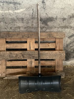 une pelle noire posée sur une caisse en bois