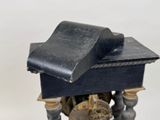 a small clock that is on a stand with a clock on it