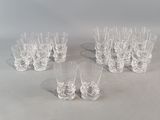 six clear glasses are lined up on a white surface