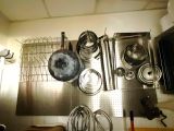 de nombreuses casseroles et poêles accrochées au mur de la cuisine
