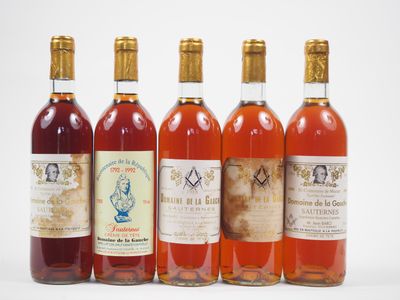 six bouteilles de vin sont alignées sur une surface blanche