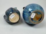 two vases with tags on them sitting on a table