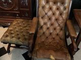 a brown leather chair sitting in a room with a black and white checkered floor