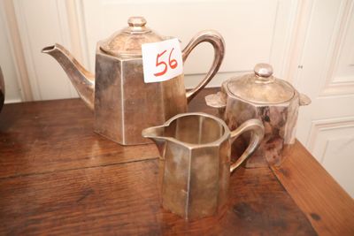 une théière en argent et une théière en argent posées sur une table en bois