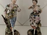 paire de figurines en porcelaine représentant un homme et une femme tenant des fleurs