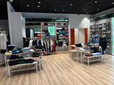 une photo d'une boutique de vêtements où sont exposés de nombreux vêtements