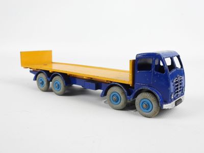 un camion jouet avec une benne sur une surface blanche