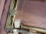 a very old brass telescope on a wooden table