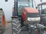 a red tractor that is parked next to a white building