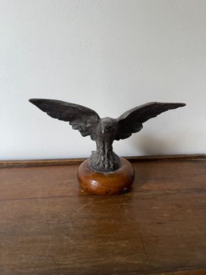 une statue représentant un aigle perché sur une table en bois