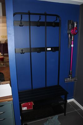 une image représentant une pièce bleue avec un banc noir et un mur bleu