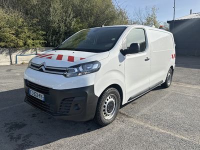 Une camionnette Citroën garée sur un parking, avec des arbres en arrière-plan