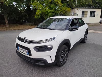 La Citroën blanche est garée dans la rue, devant une maison.