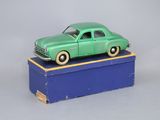 une petite voiture verte posée sur une boîte bleue