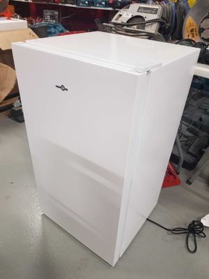a white refrigerator that is sitting in the middle of a room