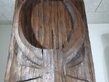 a wooden sculpture of a horned head on display