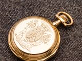 une montre de poche en or posée sur un tissu noir