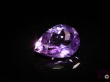 gros plan d'un diamant violet sur une surface noire
