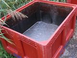 two red crates sitting next to each other in the grass