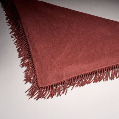 a close up of a red blanket with fringes on it