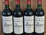 trois bouteilles de vin rouge sont alignées sur une étagère en bois