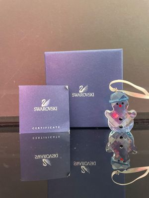 une décoration en verre représentant un ours, posée à côté d'une boîte violette