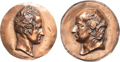 a close up of two bronze medallions of a man and a woman