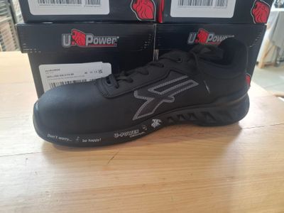 pair of black and silver running shoes sitting on top of a wooden table