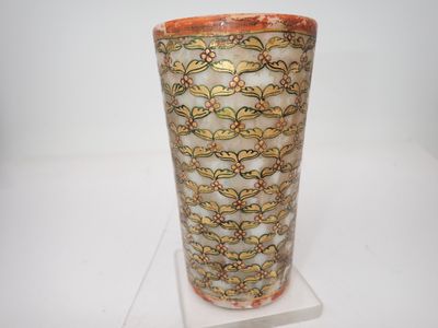 un vase posé sur un support sur une surface blanche
