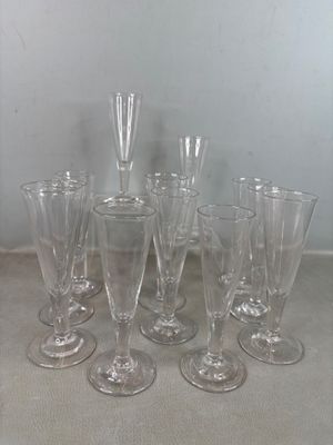 plusieurs verres à vin vides posés sur une table, avec un mur blanc en arrière-plan
