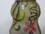 a glass vase with flowers painted on it sitting on a table