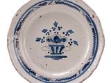 a blue and white plate with a flower design on it