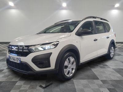 une voiture blanche est garée dans une pièce au sol à carreaux