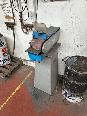 a machine that is sitting on a pallet next to a barrel