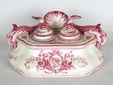 a pink and white box with a shell on top of it