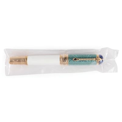un gros plan d'un stylo vert et doré sur fond blanc