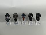 several watches are lined up in a row on a clear stand