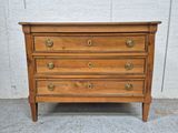 une commode en bois munie de poignées en laiton