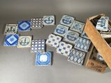 many blue and white tiles on the floor next to a wooden box