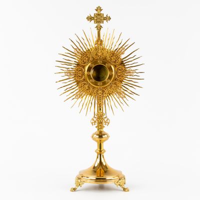 une image représentant une statue dorée du soleil sur laquelle figure une croix