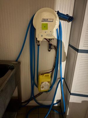 un tuyau bleu fixé au mur à côté d'un évier