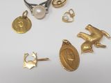 several gold and silver jewelry including a ring, a ring with a bird, a pearl, and a pearl