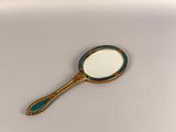 a close up of a mirror on a white surface with a blue handle