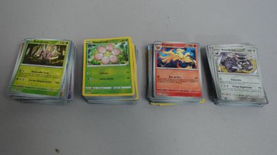 Quatre types différents de cartes Pokémon sont alignées sur une table