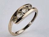 gros plan d'une bague en or ornée de trois diamants