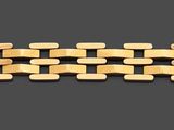 an image of a close up of a gold bracelet on a gray background