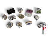 many different pieces of jewelry on display on a white surface